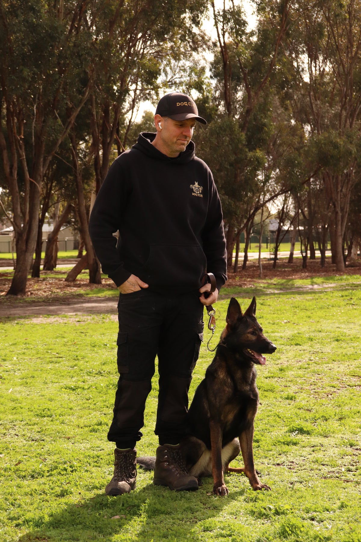 Person and dog in a park with trees and grass