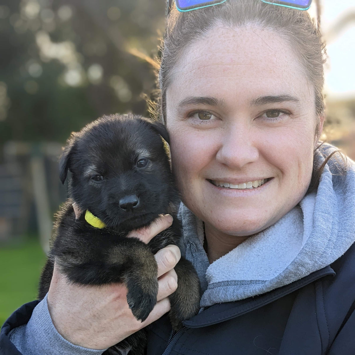 Owner holding puppy smiling at Dog Club SA puppy school